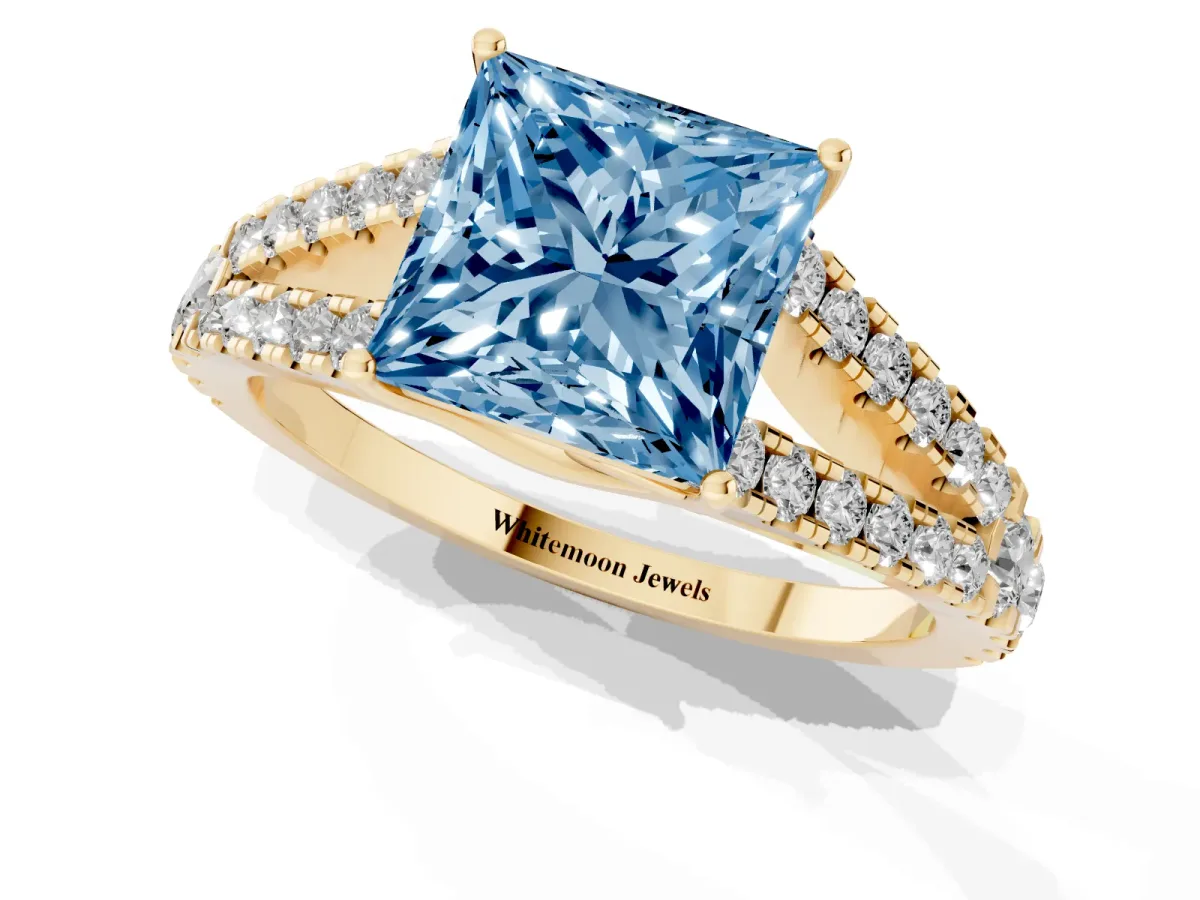Fancy Blue Princess Cut Diamond Split Shank Pavé Engagement Ring with Four-Prong Setting Yellow gold