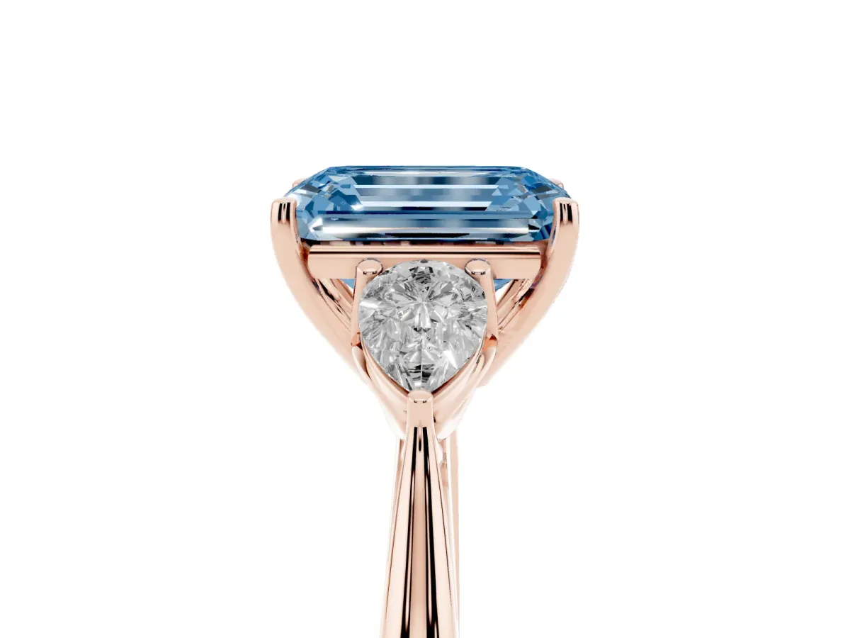 Fancy Blue Three-Stone Emerald Cut Diamond Ring with Pear Side Stones in Four-Prong Setting Rose gold