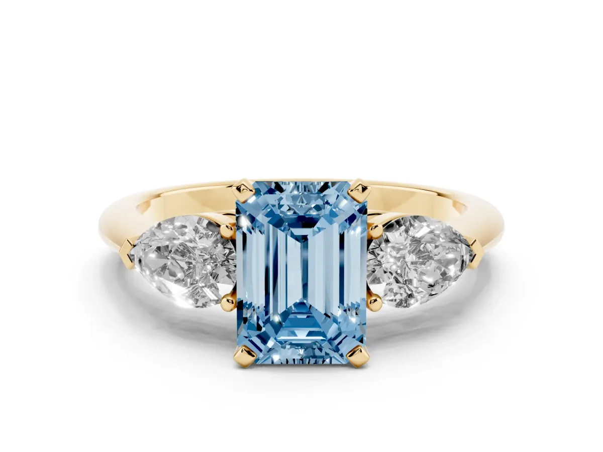 Fancy Blue Three-Stone Emerald Cut Diamond Ring with Pear Side Stones and Four-Prong Setting Yellow gold