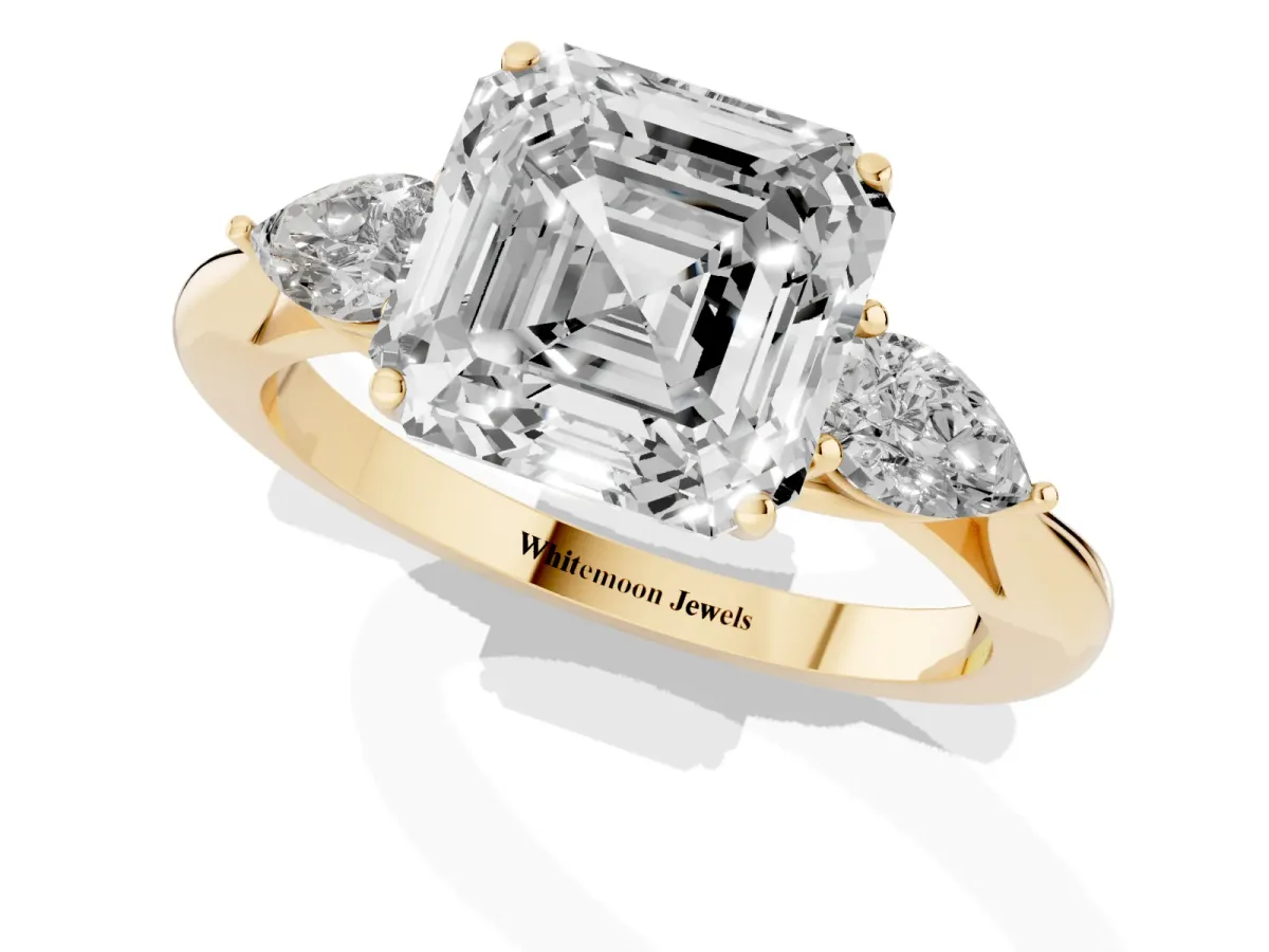 Three-Stone Asscher Cut Diamond Ring with Pear Side Stones in Four-Prong Setting Yellow gold