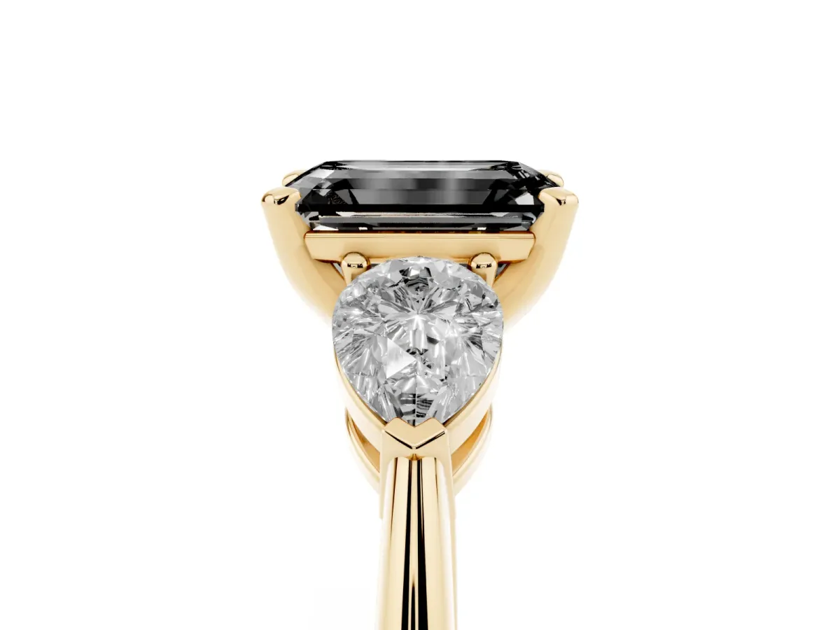 Fancy Black Three-Stone Emerald Cut Diamond Ring with Pear Side Stones and Four-Prong Setting Yellow gold