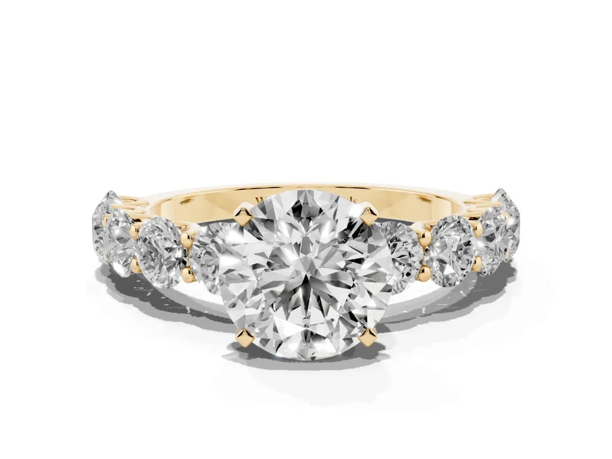 Round Cut Diamond Prong Setting with Side Stones on a Pave Band Yellow gold