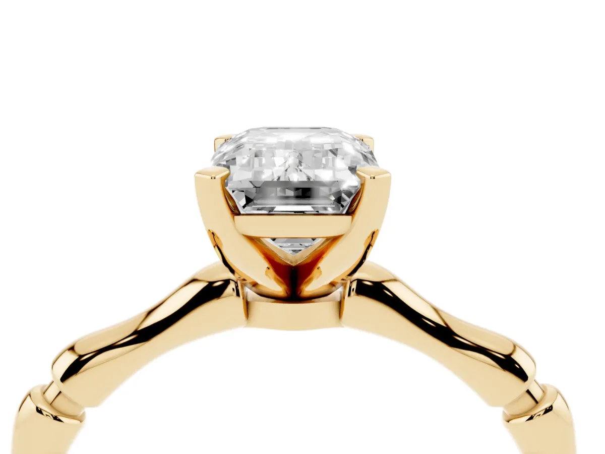 Emerald Cut Solitaire Diamond Ring with Bamboo Band and Four-Prong Setting Yellow gold