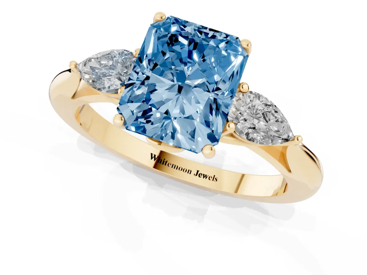 Fancy Blue Radiant Cut Diamond Three-Stone Ring with Pear Side Stones and Prong Setting Yellow gold