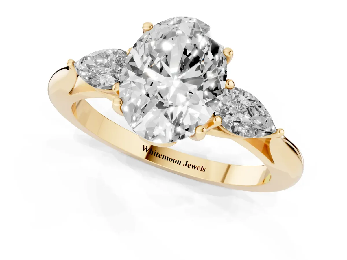 Three-Stone Oval Cut Diamond Ring with Pear Side Stones in Four-Prong Setting Yellow gold
