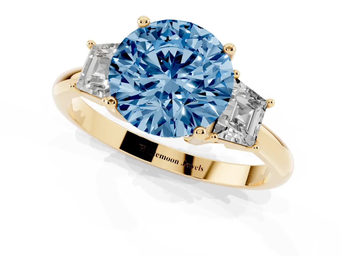 Fancy Blue Round Cut Diamond Three-Stone Ring with Trapezoid Side Stones and Prong Setting Yellow gold