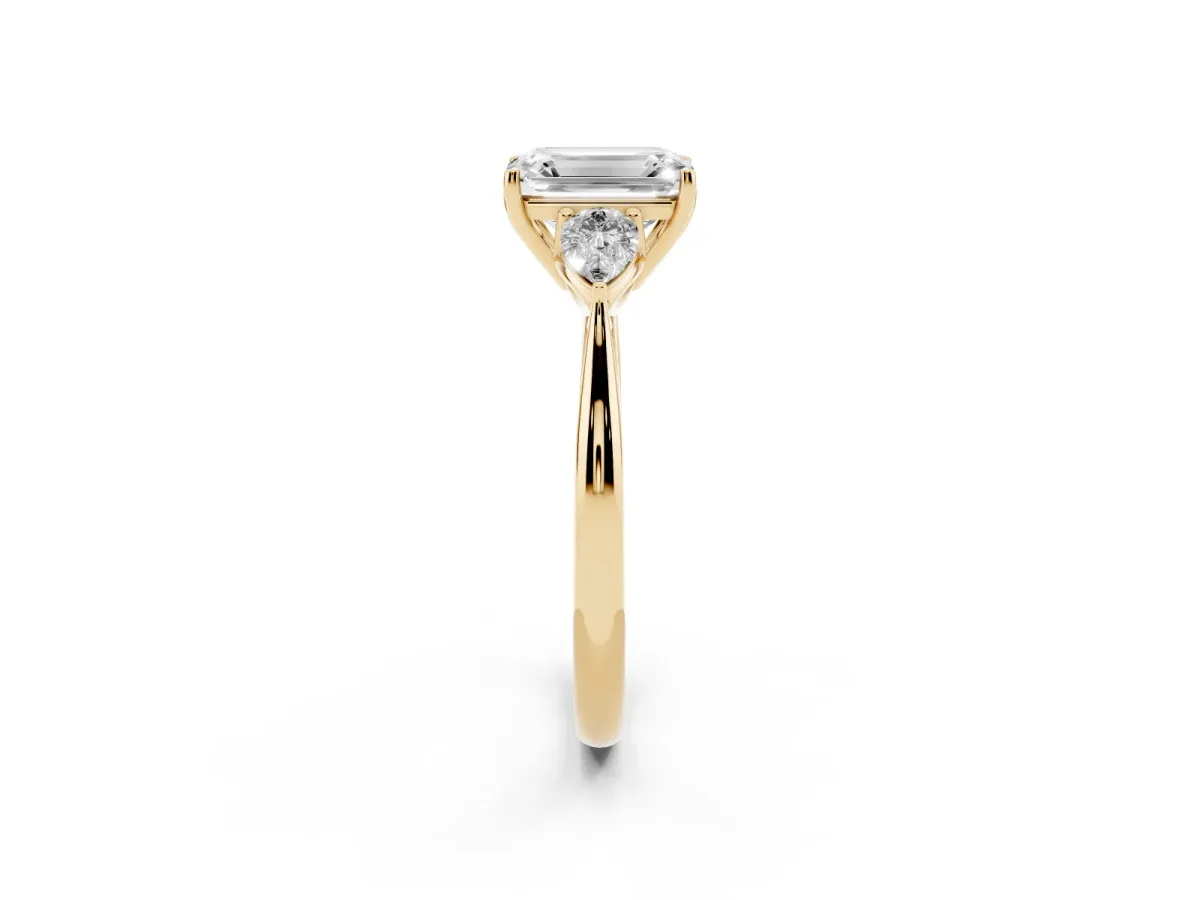 Three-Stone Emerald Cut Diamond Ring with Pear Side Stones in Four-Prong Setting Yellow gold