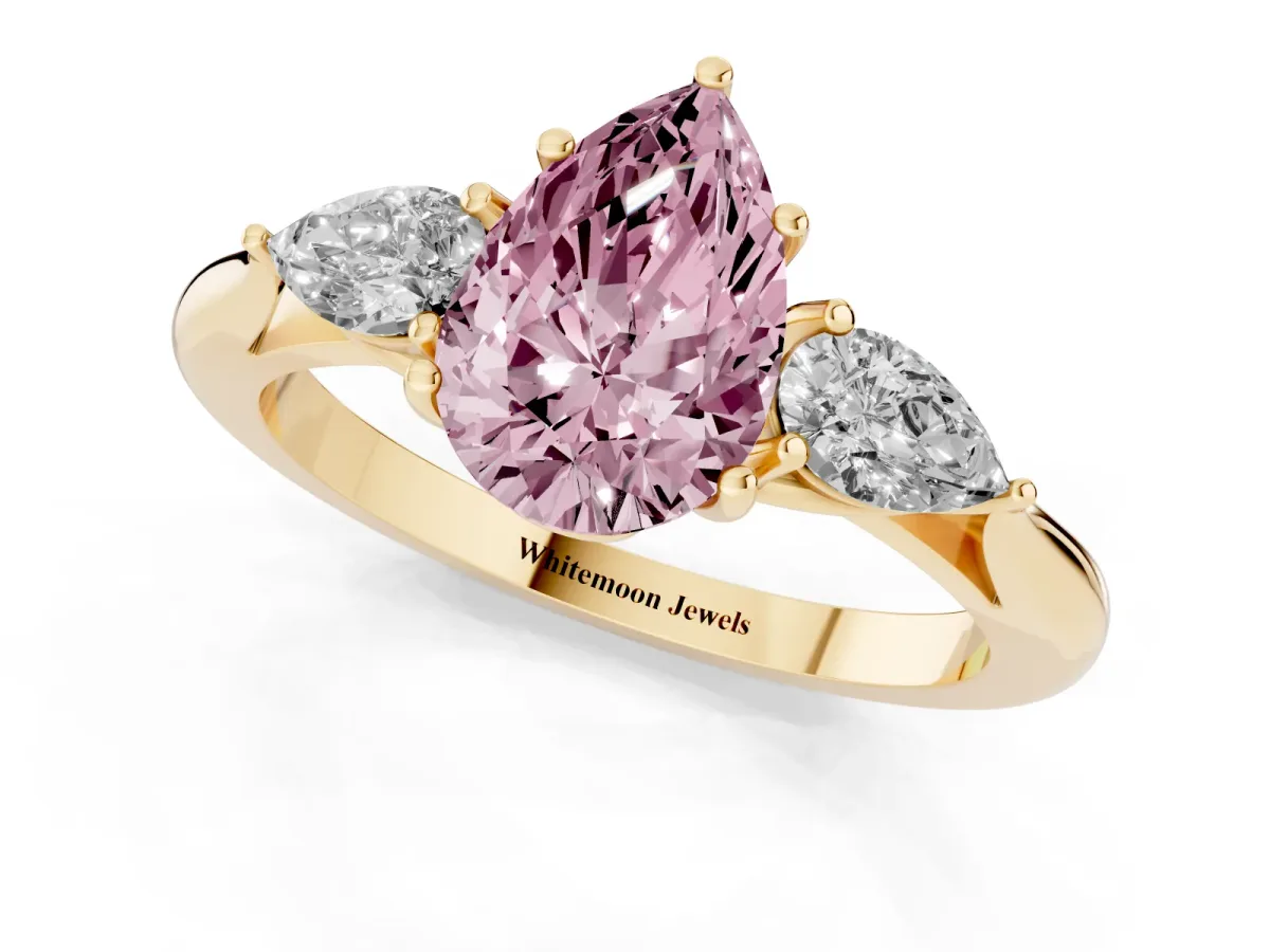Fancy Pink Three-Stone Pear Cut Brilliant Diamond Solitaire Ring with Tapered Band and Four-Prong Setting Yellow gold