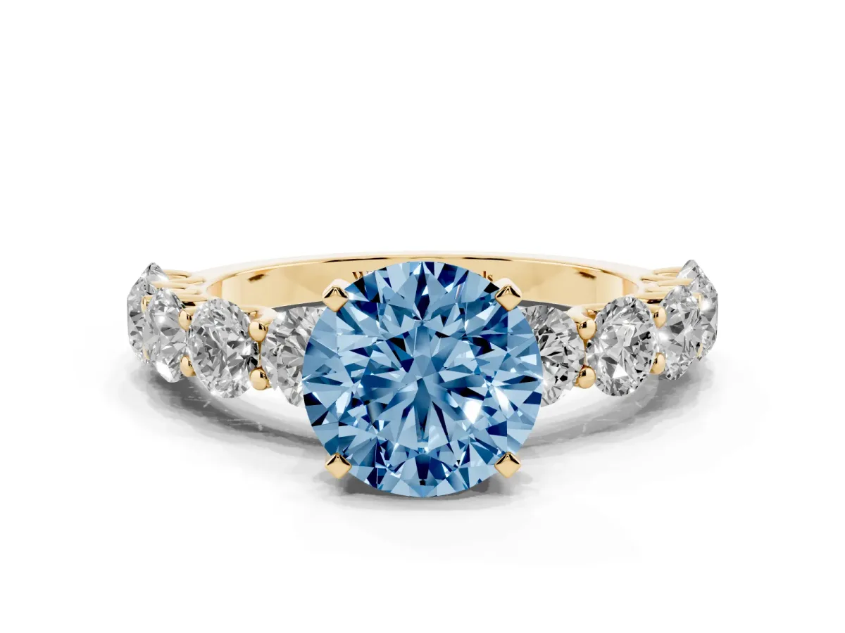 Fancy Blue Round Cut Diamond Prong Setting with Side Stones on a Pave Band Yellow gold