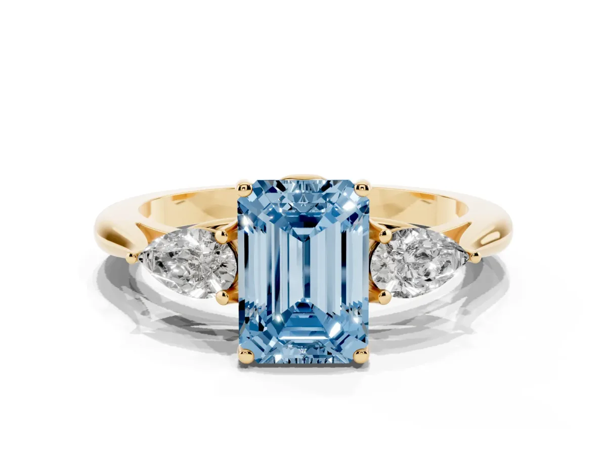 Fancy Blue Three-Stone Emerald Cut Diamond Ring with Pear Side Stones in Four-Prong Setting Yellow gold
