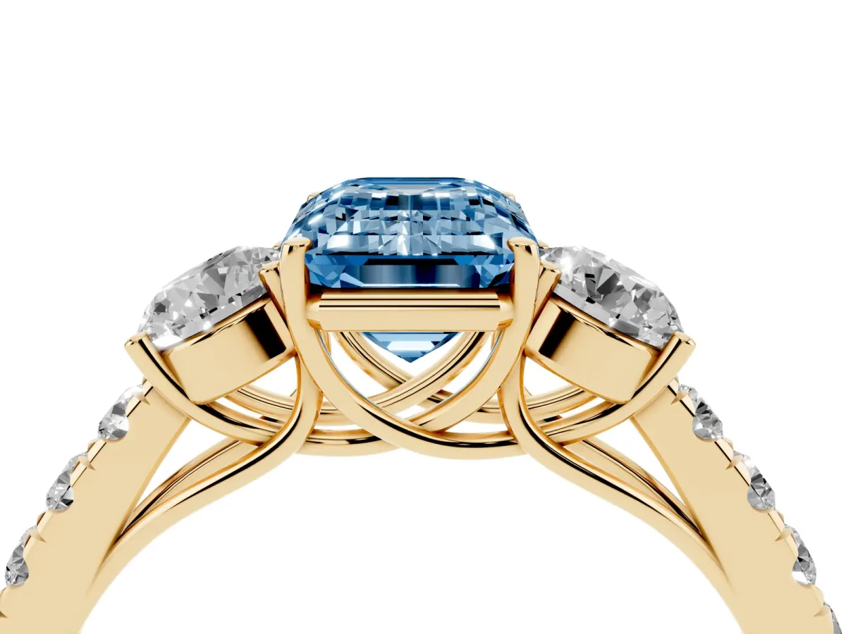 Fancy Blue Emerald Cut Cut Diamond Three-Stone Ring with Round Side Stones and Pavé Band Yellow gold