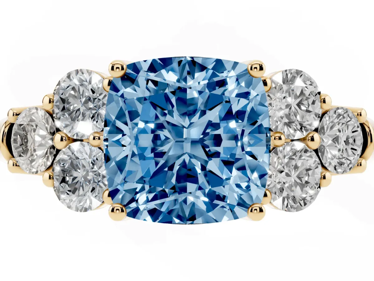 Fancy Blue Cushion Cut Cut Diamond Cluster Ring with Round Accent Stones and Prong Setting on a Classic Band Yellow gold