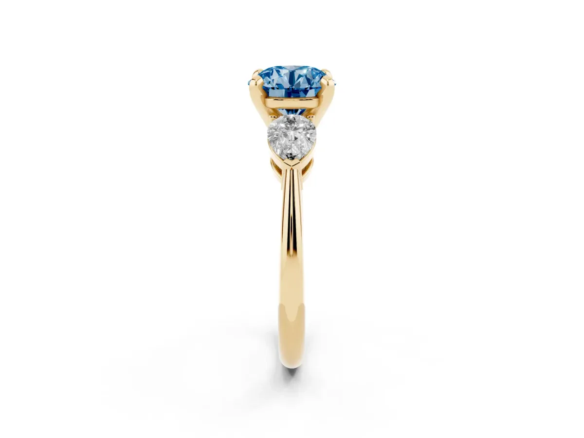 Fancy Blue Three-Stone Round Cut Diamond Ring with Pear Side Stones and Four-Prong Setting Yellow gold