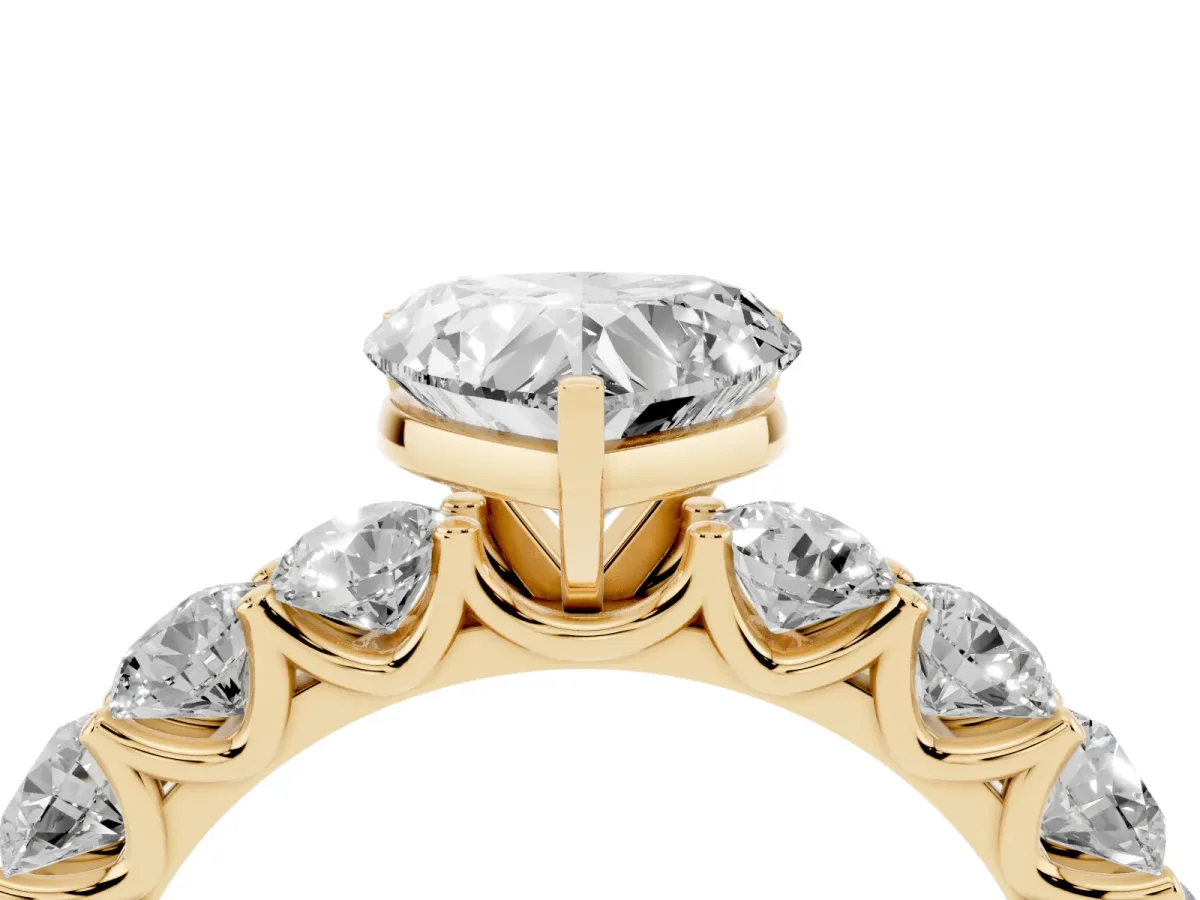 Heart Cut Diamond Prong Setting with Side Stones on a Pave Band Yellow gold