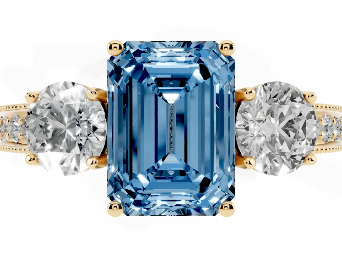 Fancy Blue Emerald Cut Three-Stone Diamond Ring with Pavé Band and Four-Prong Setting Yellow gold