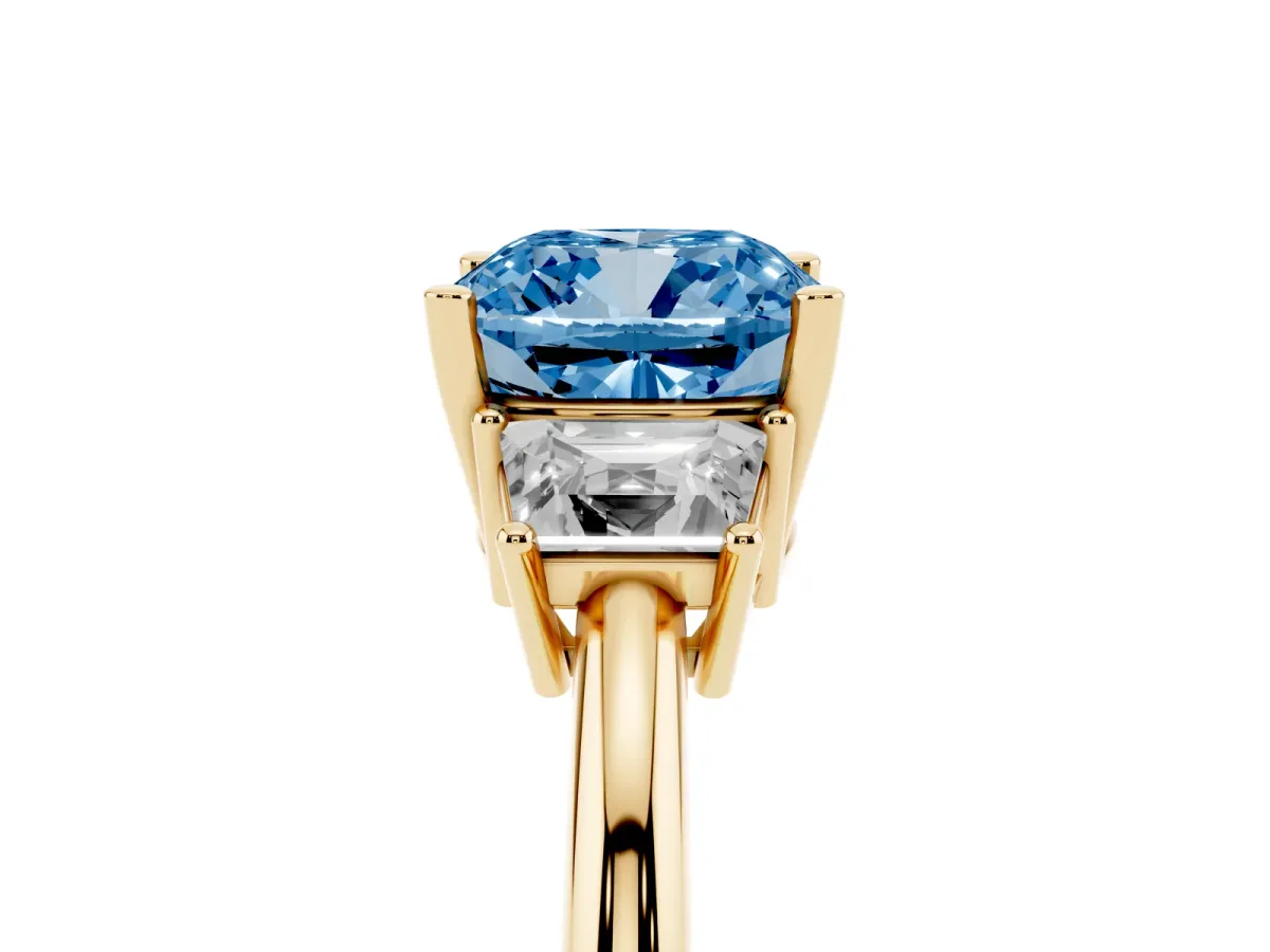 Fancy Blue Cushion Cut Diamond Three-Stone Ring with Trapezoid Side Stones and Prong Setting Yellow gold