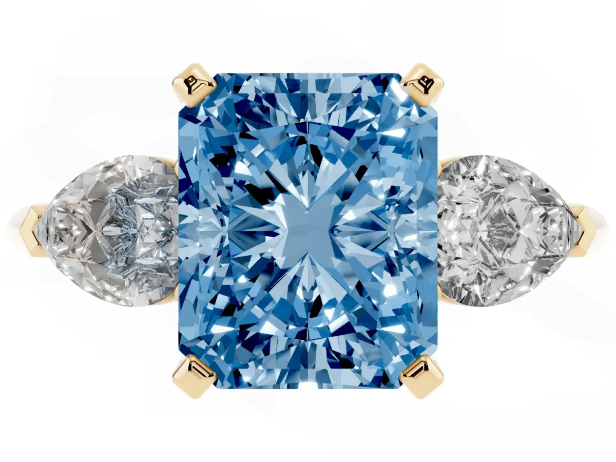 Fancy Blue Three-Stone Radiant Cut Diamond Ring with Pear Side Stones and Four-Prong Setting Yellow gold