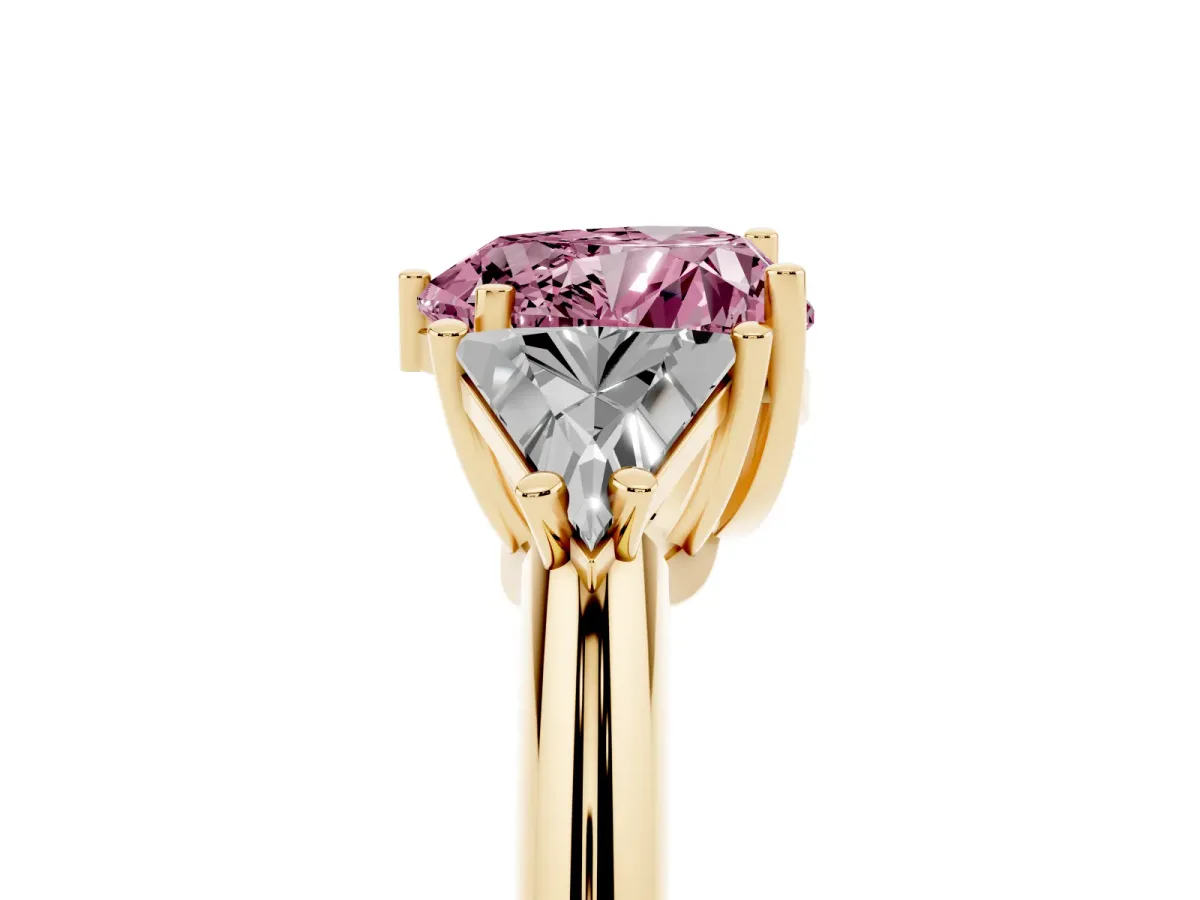 Fancy Pink Three-Stone Heart Cut Diamond Engagement Ring with Trillion Side Stones and Prong Setting Yellow gold