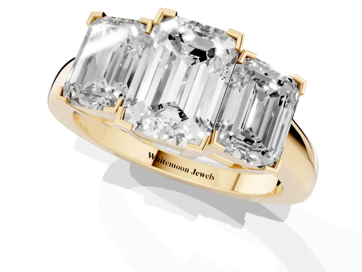 Three-Stone Emerald Cut Cut Diamond Ring with Channel Set Band and Four-Prong Setting Yellow gold