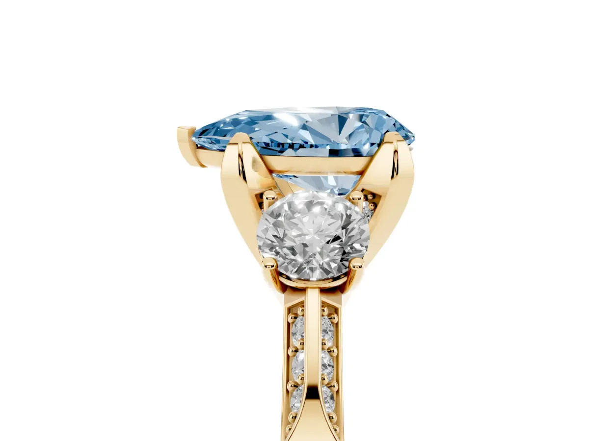 Fancy Blue Pear Cut Brilliant Three-Stone Diamond Ring with Pavé Band and Four-Prong Setting Yellow gold