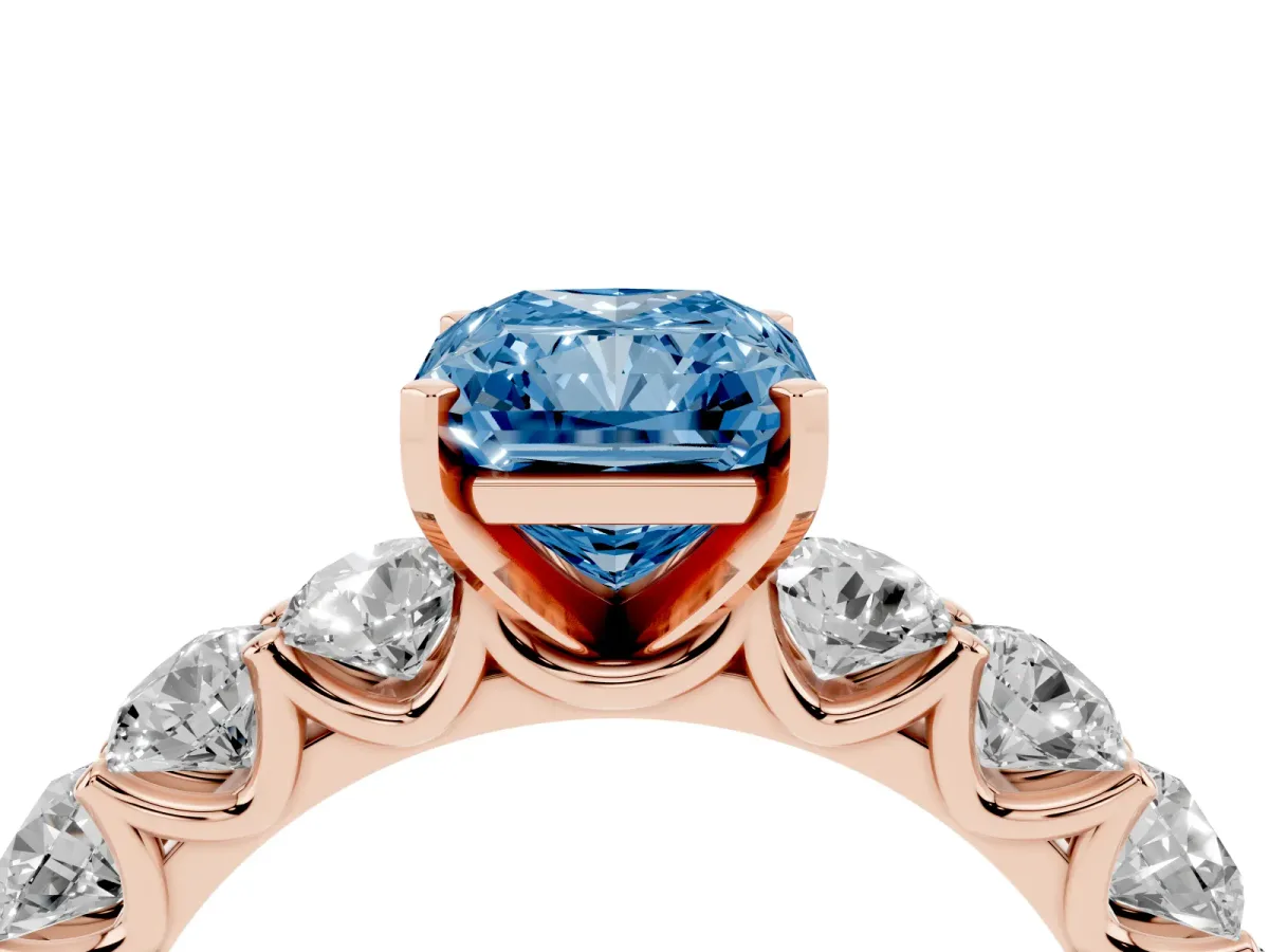 Fancy Blue Radiant Cut Diamond Prong Setting with Side Stones on a Pave Band Rose gold