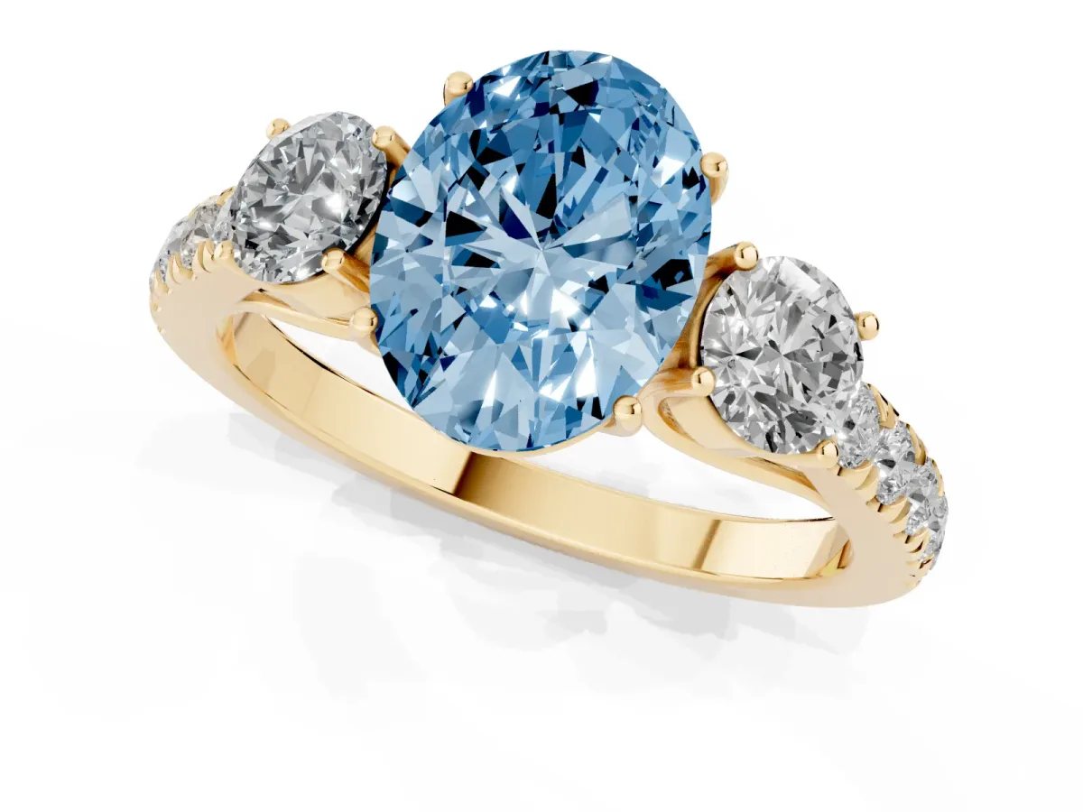 Fancy Blue Oval Cut Cut Diamond Three-Stone Ring with Round Side Stones and Pavé Band Yellow gold