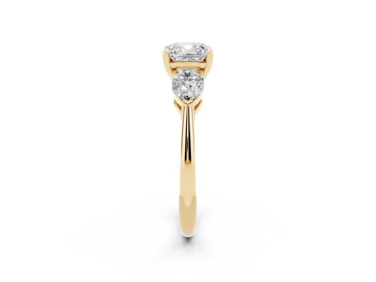 Three-Stone Cushion Cut Diamond Ring with Pear Side Stones and Four-Prong Setting Yellow gold