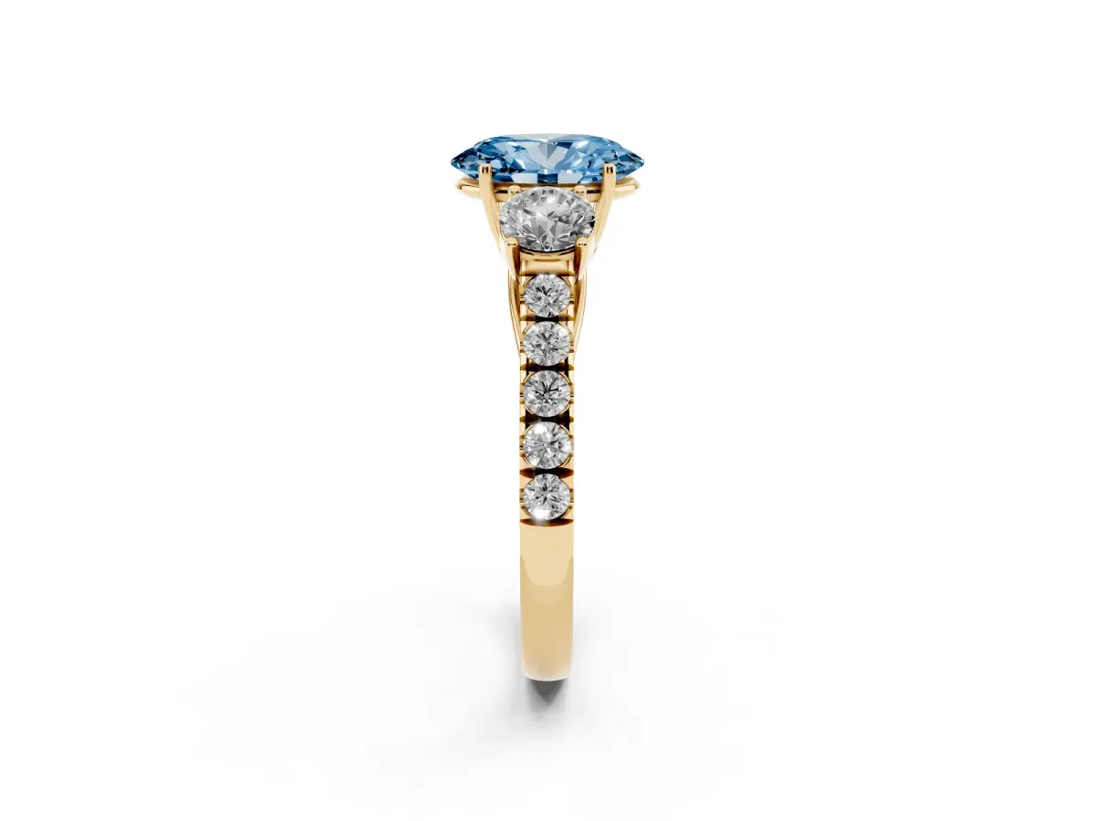 Fancy Blue Oval Cut Cut Diamond Three-Stone Ring with Round Side Stones and Pavé Band Yellow gold