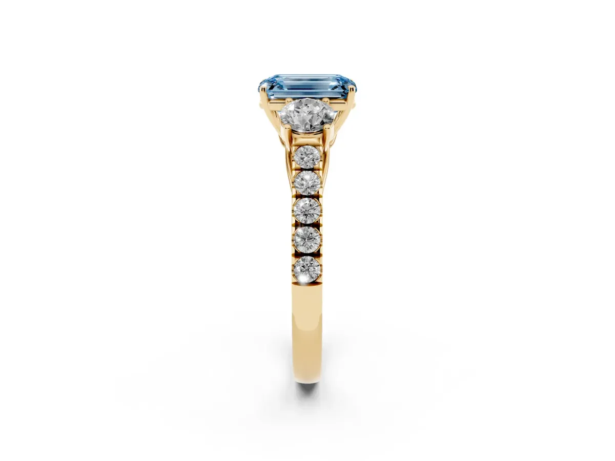 Fancy Blue Emerald Cut Cut Diamond Three-Stone Ring with Round Side Stones and Pavé Band Yellow gold