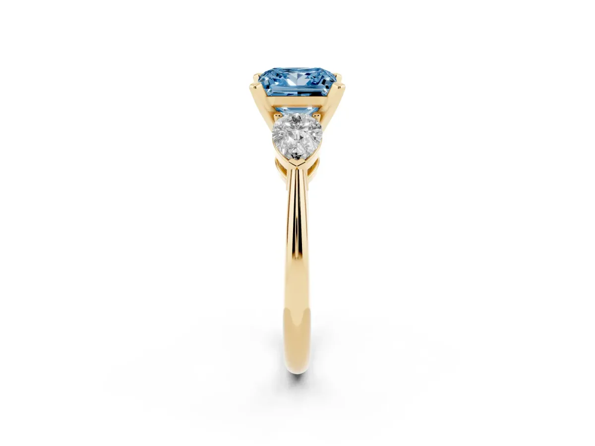 Fancy Blue Three-Stone Princess Cut Diamond Ring with Pear Side Stones and Four-Prong Setting Yellow gold