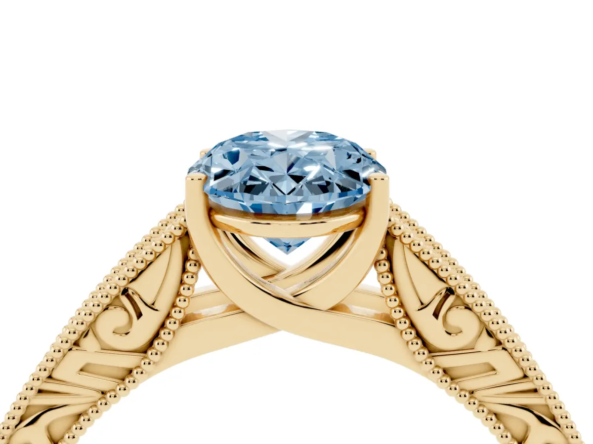 Fancy Blue Oval Cut Diamond Solitaire Ring with Engraved Band and Four-Prong Setting Yellow gold