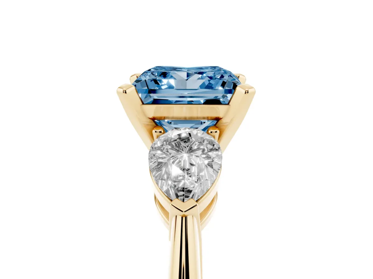 Fancy Blue Three-Stone Princess Cut Diamond Ring with Pear Side Stones and Four-Prong Setting Yellow gold