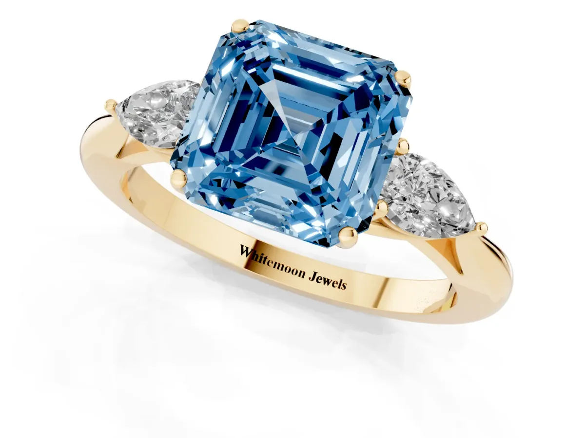 Fancy Blue Asscher Cut Diamond Three-Stone Ring with Pear Side Stones and Prong Setting Yellow gold
