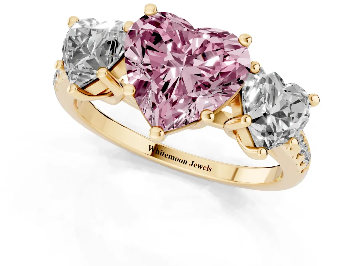 Fancy Pink Three-Stone Heart Cut Diamond Ring with Round Pavé Band and Prong Setting Yellow gold