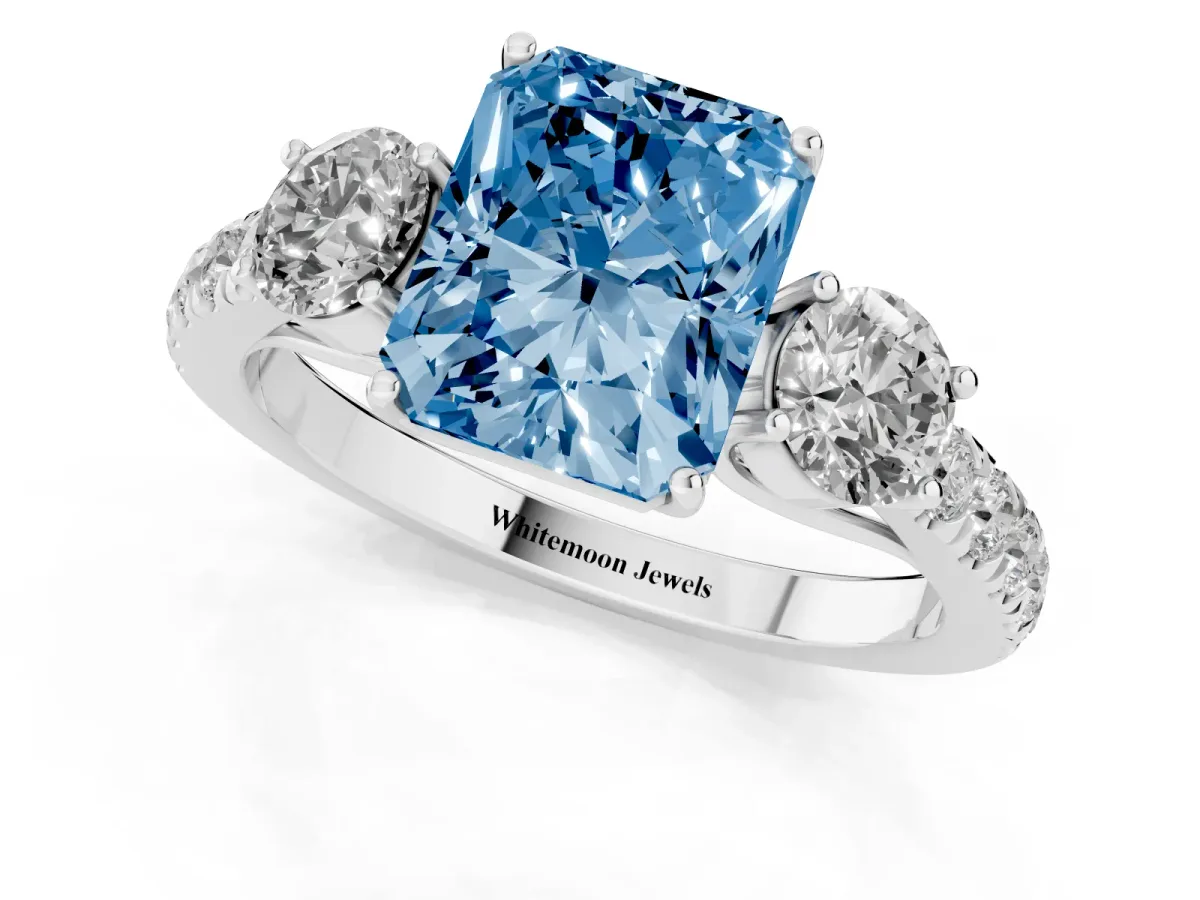 Fancy Blue Radiant Cut Cut Diamond Three-Stone Ring with Round Side Stones and Pavé Band White gold