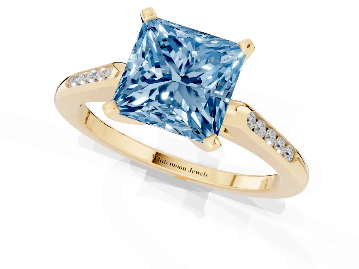 Fancy Blue Princess Cut Diamond Solitaire Ring with Channel Set Round Band and Prong Setting Yellow gold