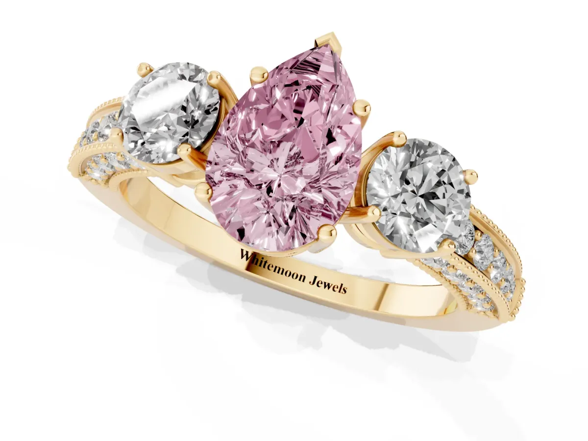 Fancy Pink Pear Cut Three-Stone Diamond Ring with Pavé Band and Four-Prong Setting Yellow gold