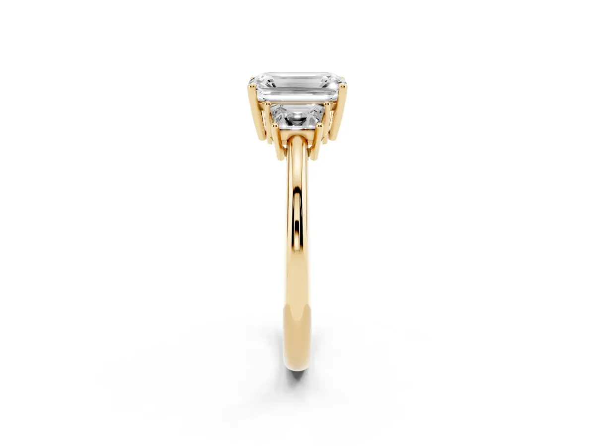 Emerald Cut Diamond Three-Stone Ring with Trapezoid Side Stones and Prong Setting Yellow gold