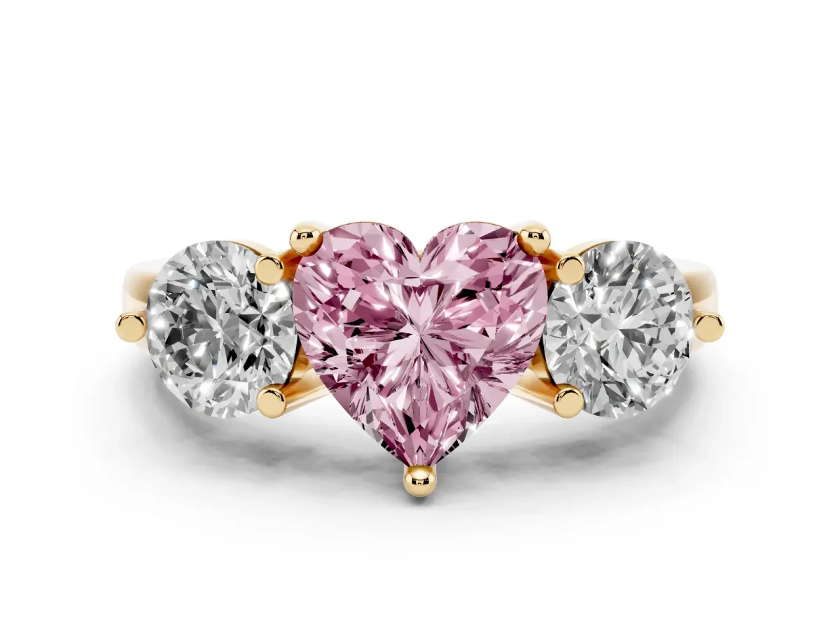 Fancy Pink Three-Stone Heart Cut Brilliant Cut Solitaire Ring with Prong Setting on a Classic Band Yellow gold