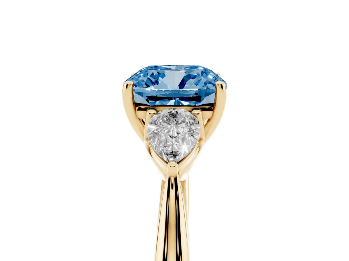 Fancy Blue Three-Stone Cushion Cut Diamond Ring with Pear Side Stones in Four-Prong Setting Yellow gold
