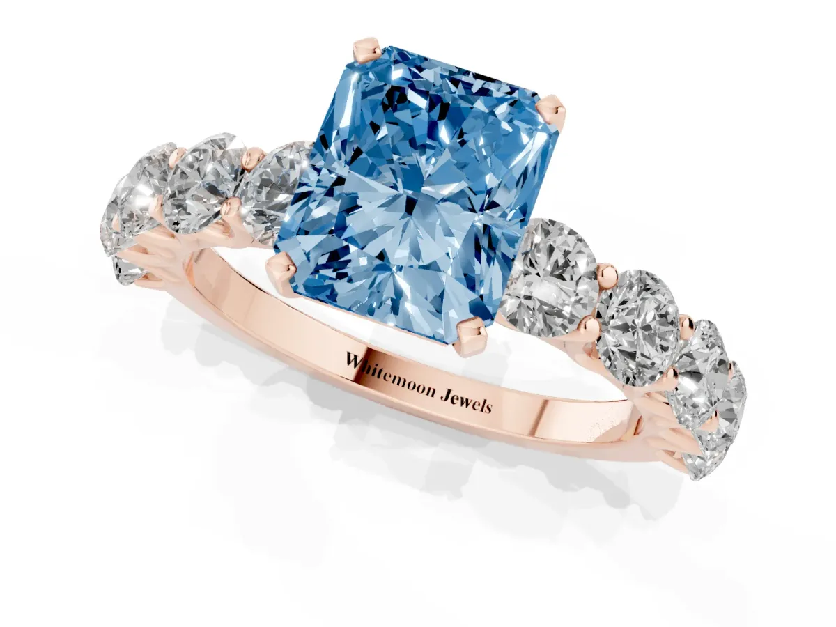 Fancy Blue Radiant Cut Diamond Prong Setting with Side Stones on a Pave Band Rose gold