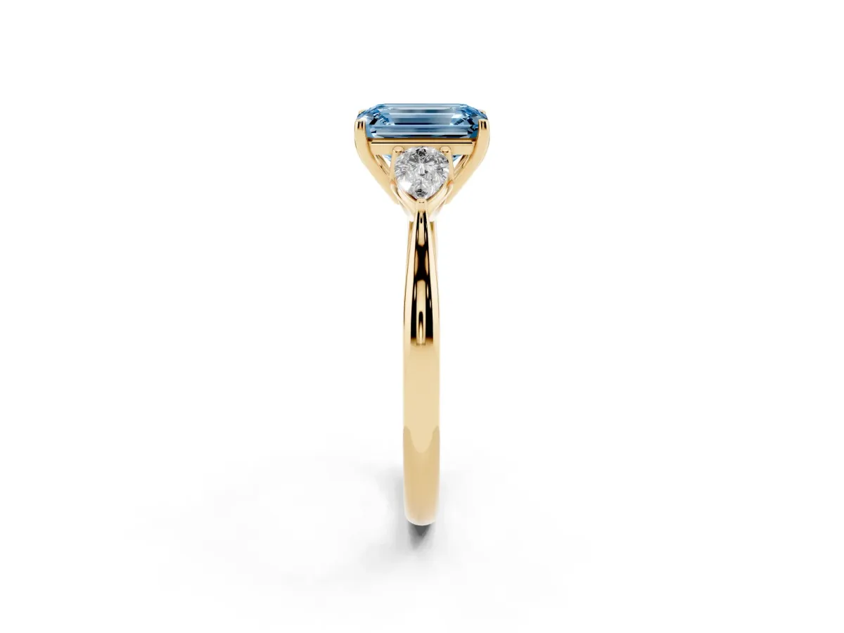 Fancy Blue Three-Stone Emerald Cut Brilliant Diamond Solitaire Ring with Tapered Band and Four-Prong Setting Yellow gold