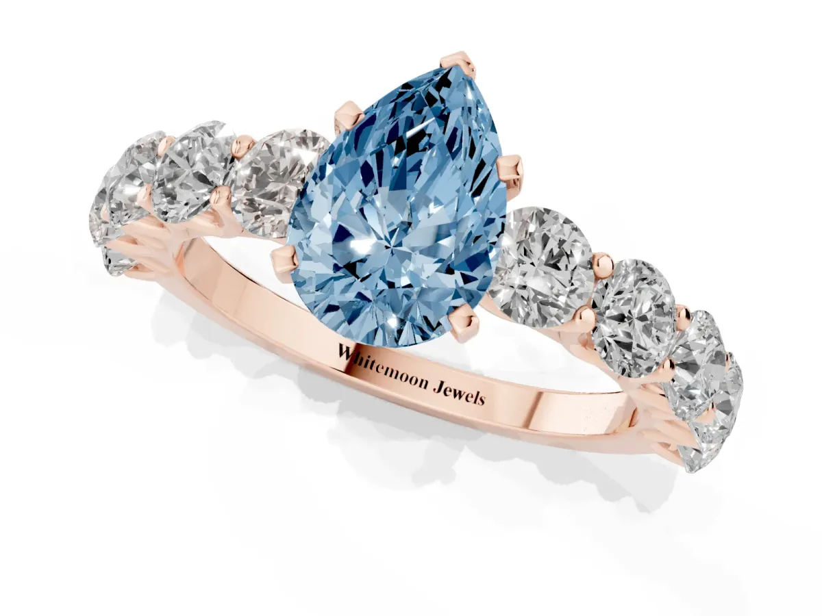 Fancy Blue Pear Cut Diamond Prong Setting with Side Stones on a Pave Band Rose gold