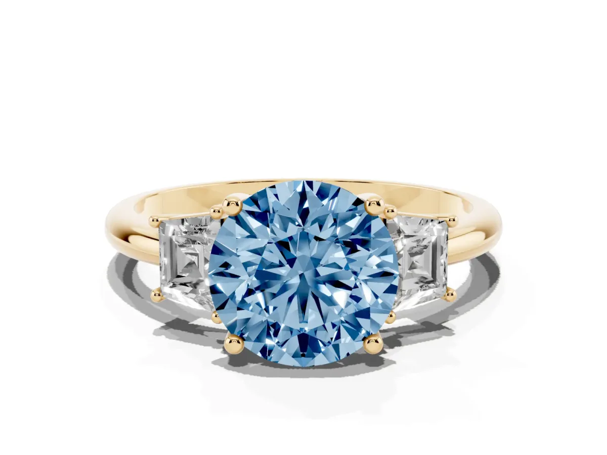 Fancy Blue Round Cut Diamond Three-Stone Ring with Trapezoid Side Stones and Prong Setting Yellow gold