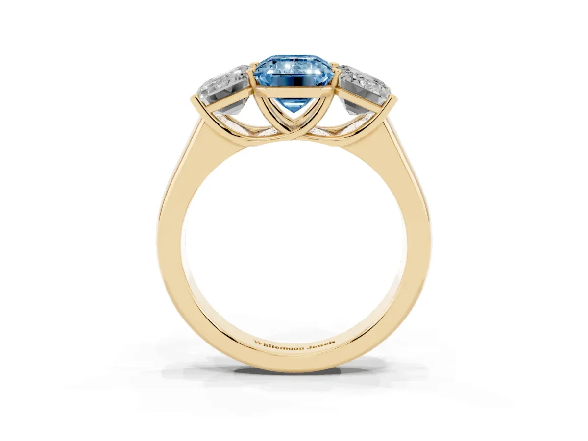 Fancy Blue Emerald Cut Three-Stone Diamond Ring with Prong Setting on a Classic Band Yellow gold
