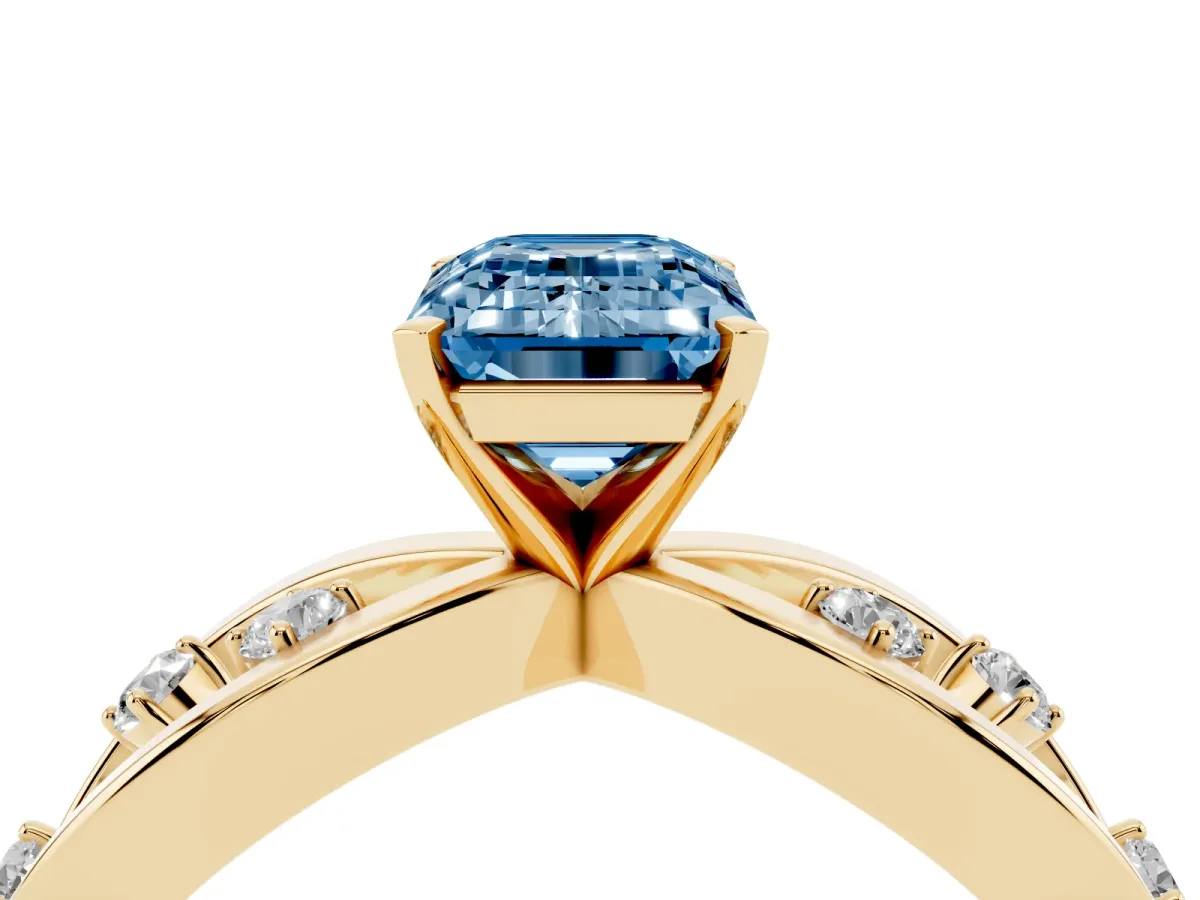 Fancy Blue Emerald Cut Cut Solitaire Diamond with Side Stones on Criss-Cross Band and Four-Prong Setting Yellow gold