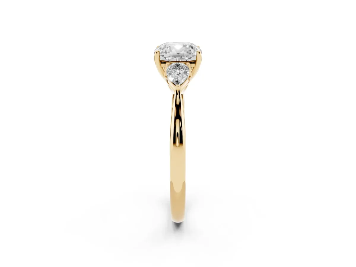 Three-Stone Cushion Cut Diamond Ring with Pear Side Stones in Four-Prong Setting Yellow gold