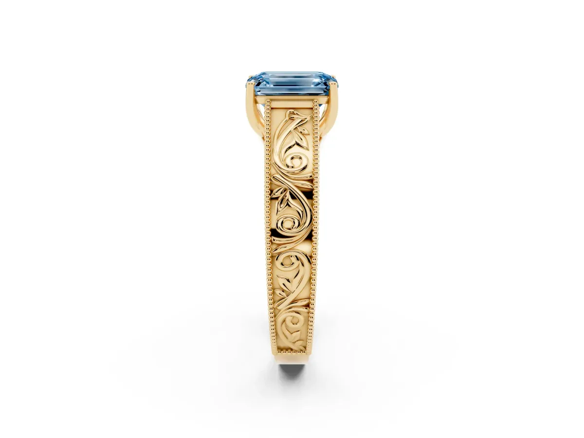 Fancy Blue Emerald Cut Diamond Solitaire Ring with Engraved Band and Four-Prong Setting Yellow gold