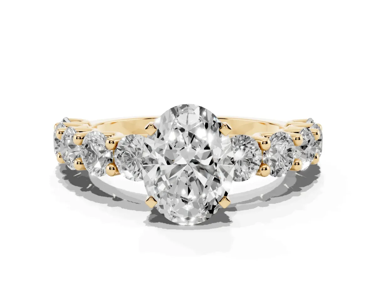 Oval Cut Diamond Prong Setting with Side Stones on a Pave Band Yellow gold
