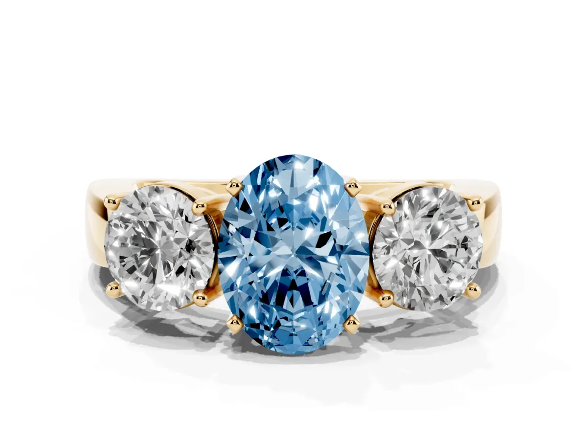 Fancy Blue Three-Stone Oval Cut Diamond Ring with Round Side Stones, Classic Band, and Four-Prong Setting Yellow gold